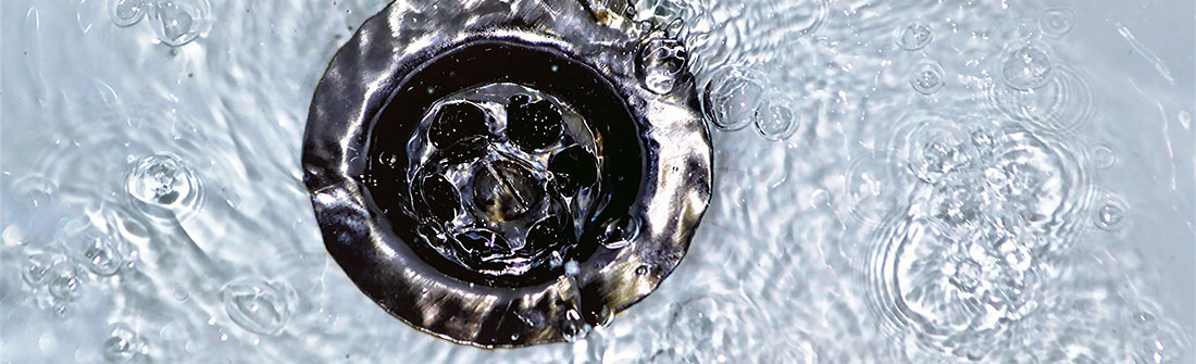 Plumber using professional tools to clear a clogged drain.