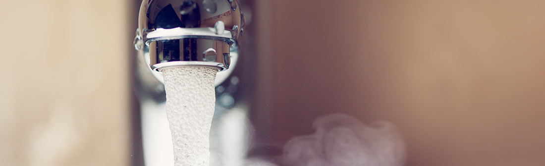 Professional plumber fixing a water heater in Birmingham home.