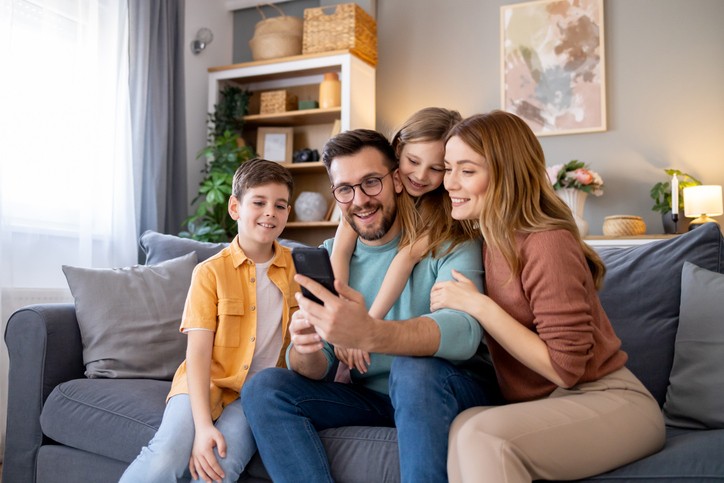 Happy family in living room looking at phone